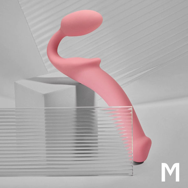 Pink silicone curved personal massager on a grey geometric background