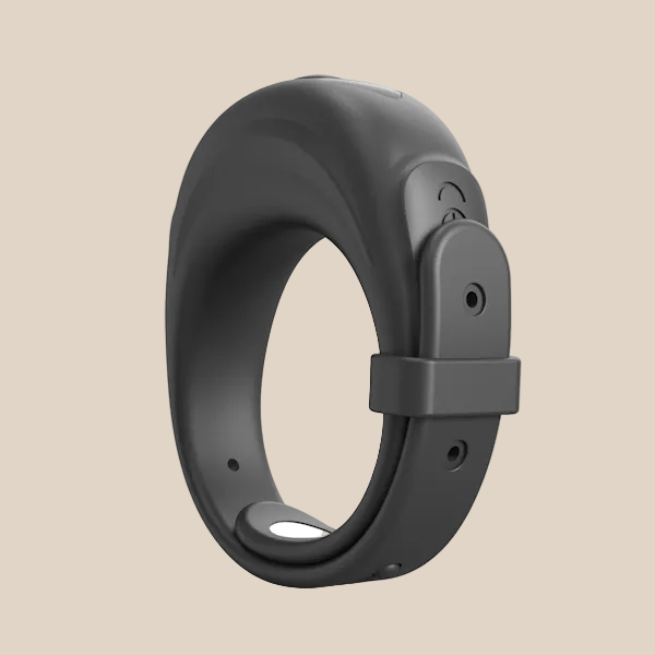 Adjustable black silicone vibrating ring on a beige background, modern adult intimacy essential