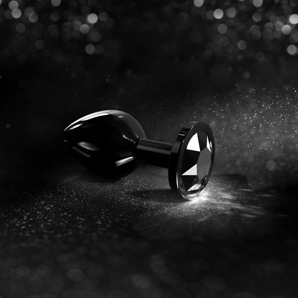 Black jeweled plug with diamond-like base on a dark, sparkling background