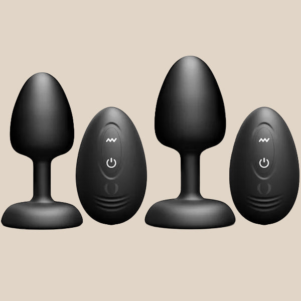 Black silicone vibrating plug set with remote controls on beige background