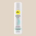 Pjur Woman Nude 100ml water-based personal lubricant bottle on beige background
