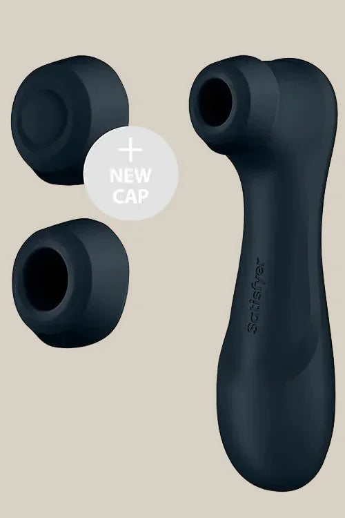 Black silicone suction stimulator with two interchangeable caps on beige background