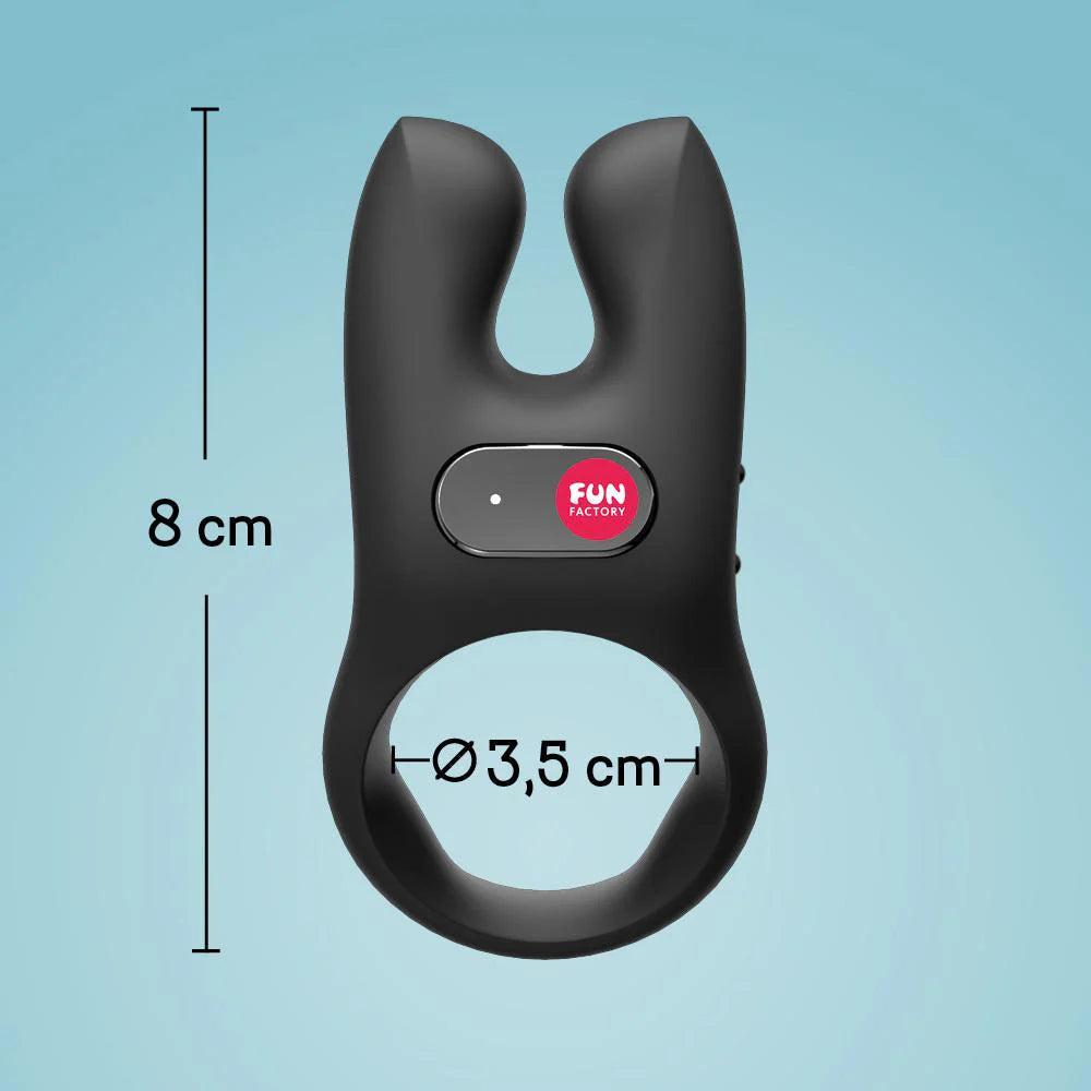 Black silicone vibrating cock ring with dual prongs, 8 cm tall, 3.5 cm diameter, on blue background.