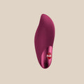 Body-safe silicone clitoral vibrator in deep pink with ergonomic shape on white background
