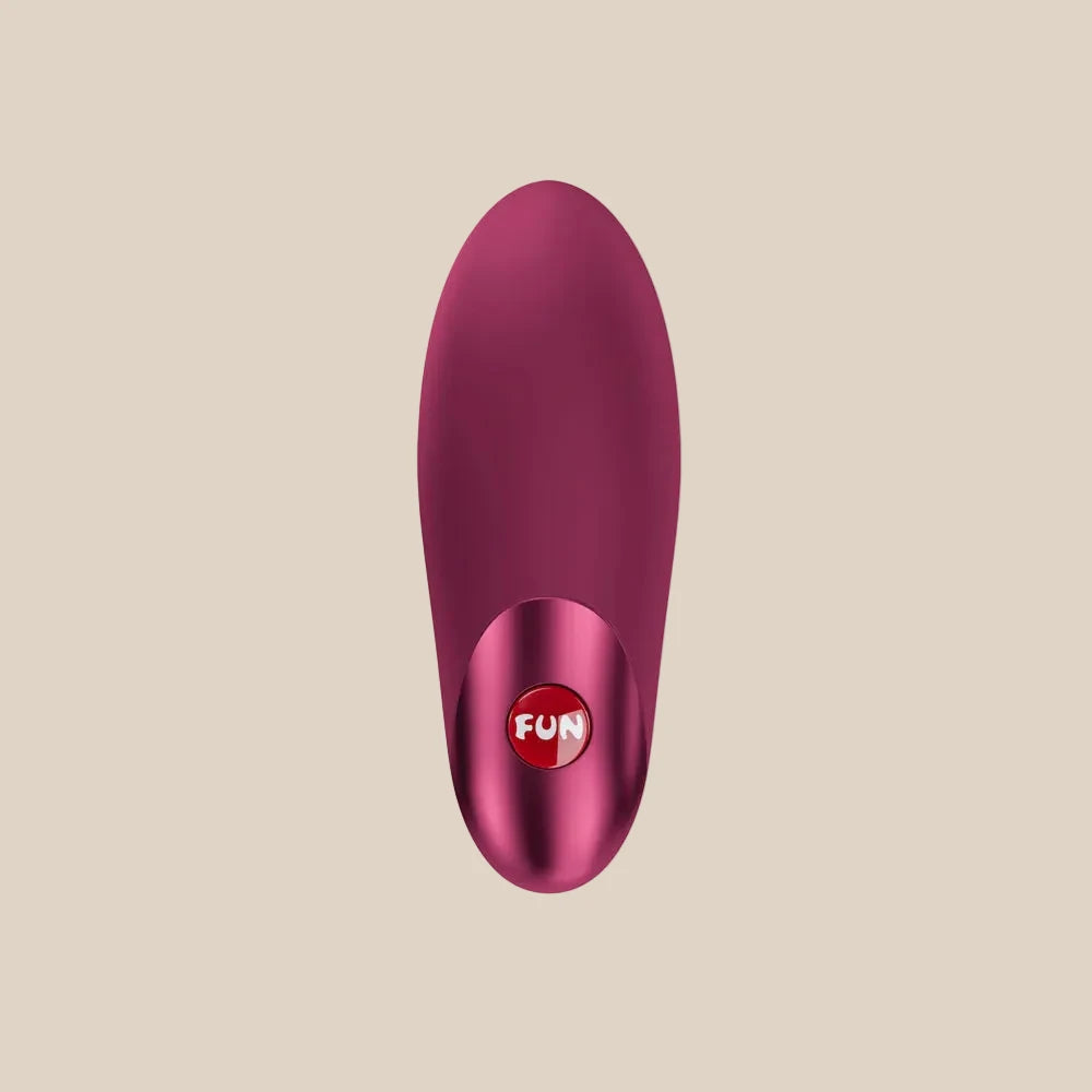 Plum-colored silicone personal massager with 'FUN' button, white background