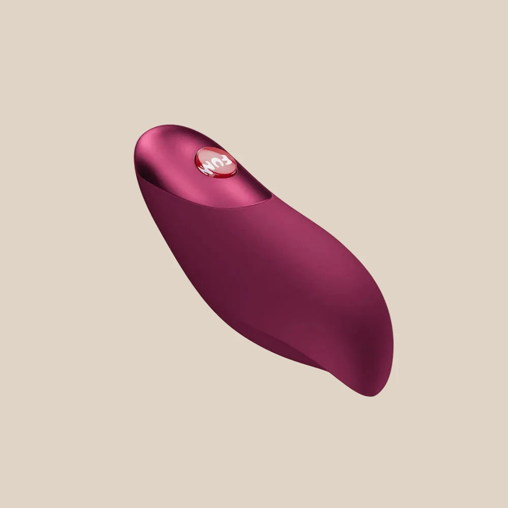 Plum-colored silicone personal massager with curved ergonomic shape on white background