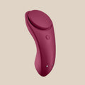Maroon silicone rechargeable personal massager with ergonomic design on beige background