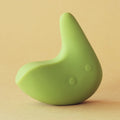 Green silicone intimate massager with ergonomic design on a beige background