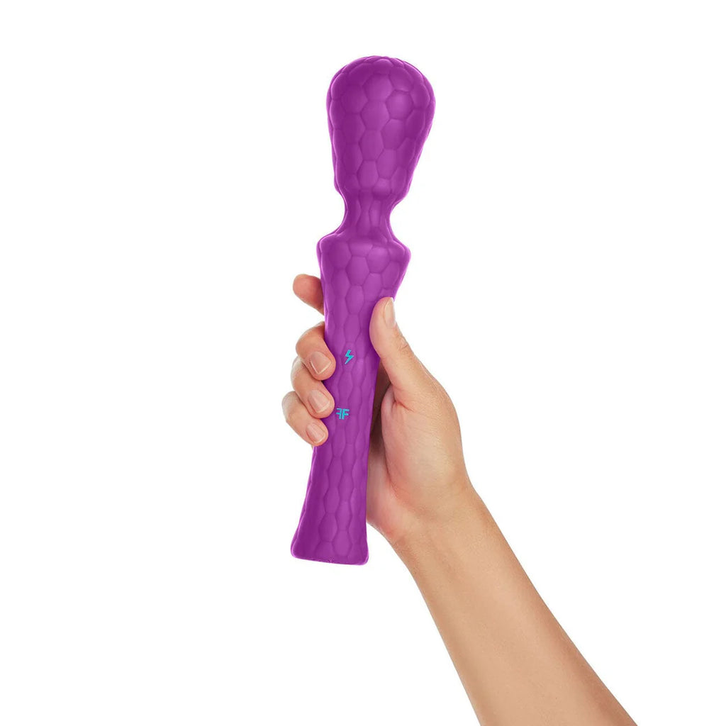 Hand holding a purple textured silicone wand massager with power buttons visible.