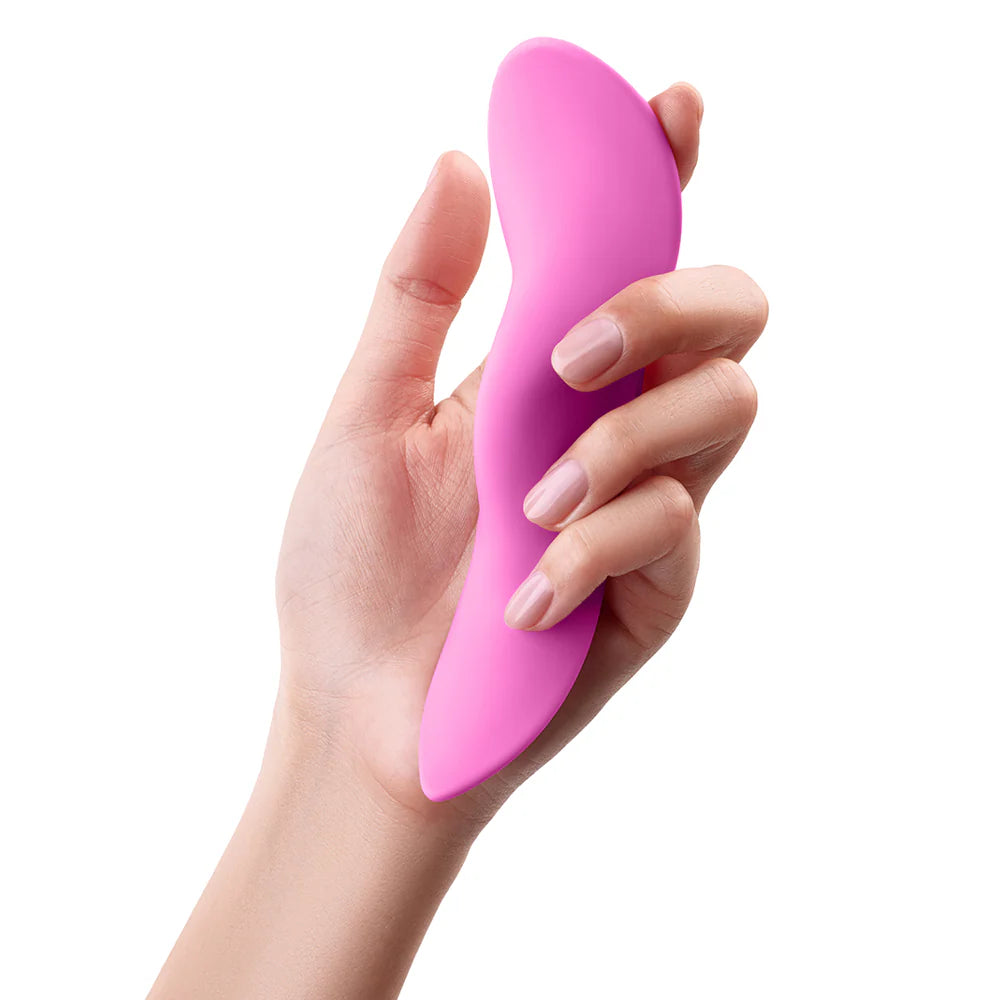 Hand holding a pink silicone personal massager against a white background