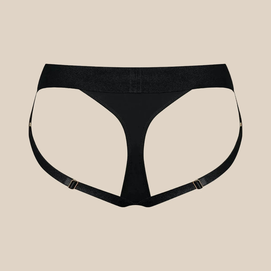 Black strappy thong with adjustable side straps on beige background, modern intimate wear