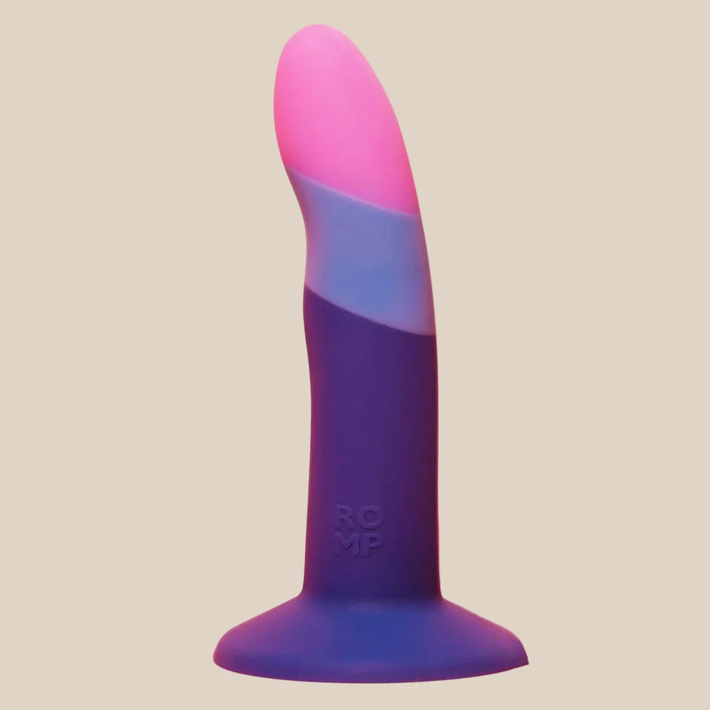 Colorful silicone adult toy with curved design and suction base, displayed on pink background.