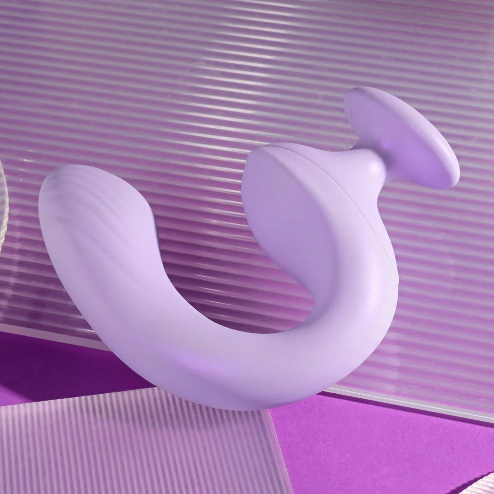 Purple silicone curved dual-ended adult toy on textured purple background
