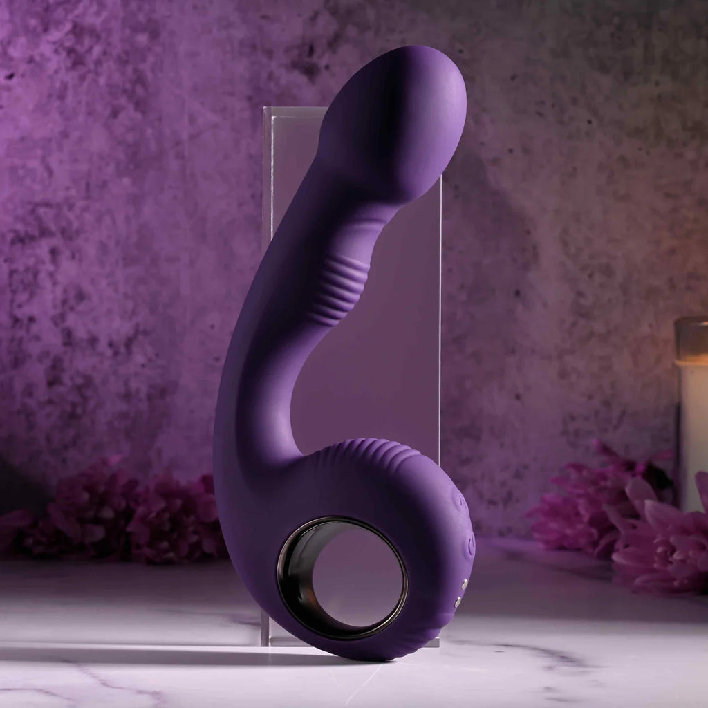 Purple silicone vibrator with ergonomic handle and textured shaft on marble tabletop