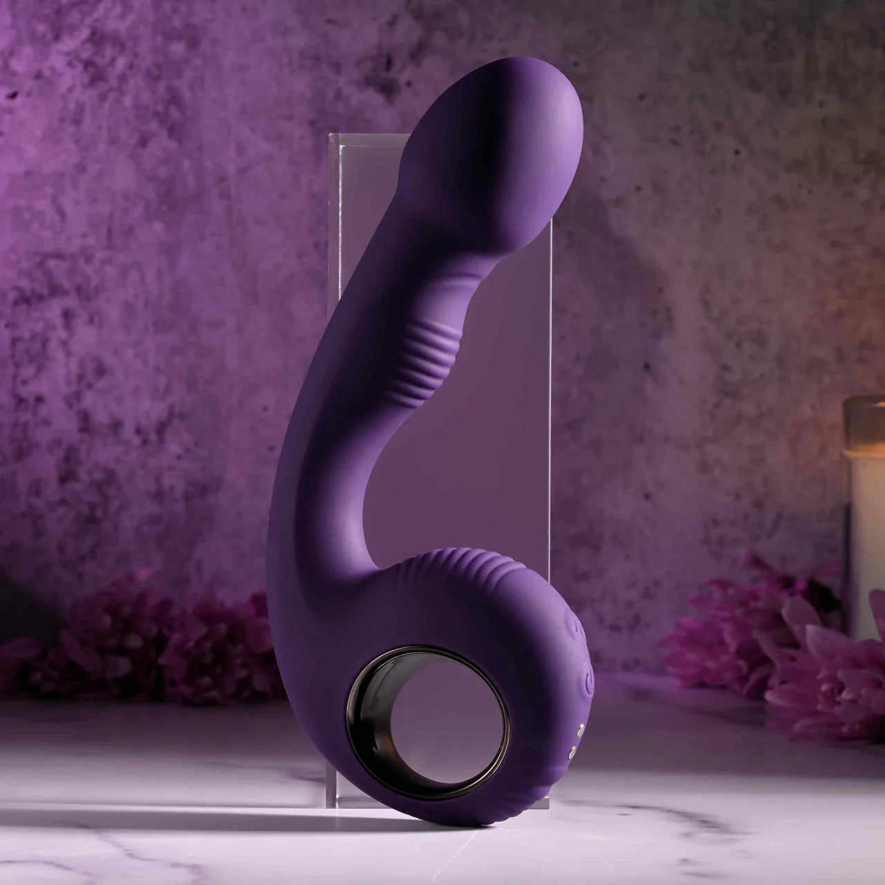 Purple silicone vibrator with ergonomic handle and textured shaft on marble tabletop