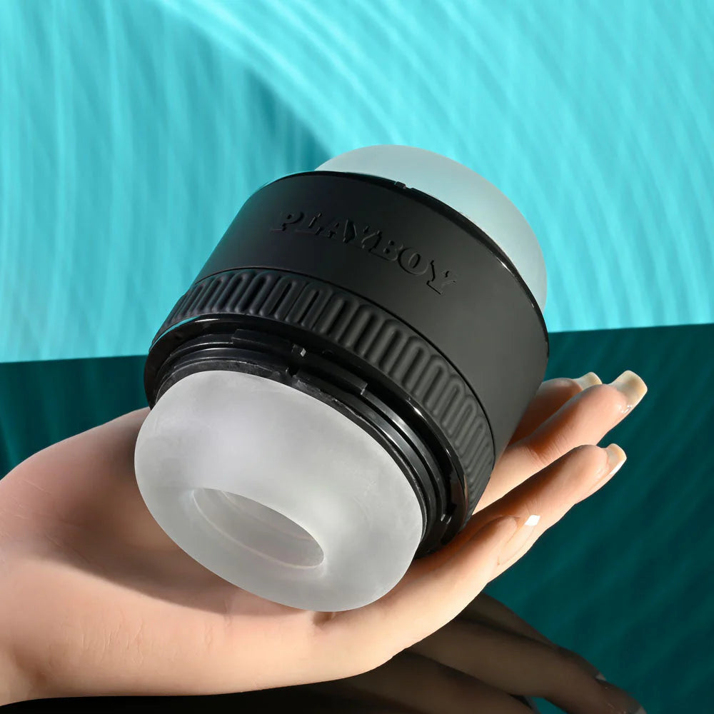 Hand holding a black and translucent silicone personal massager against a teal background