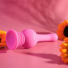 Pink silicone pleasure wand on pink background with sunflowers, intimacy essential product