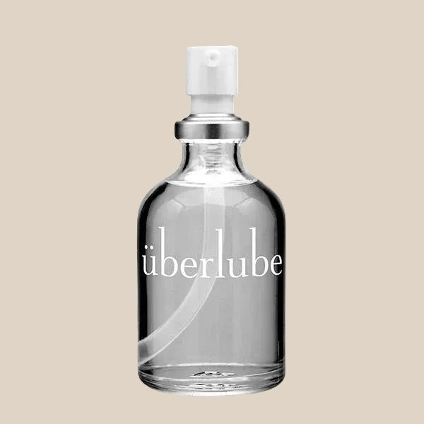 Clear glass bottle of personal lubricant with pump dispenser on neutral background