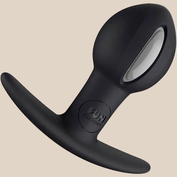 Black silicone butt plug with ergonomic base and metallic accent on neutral background