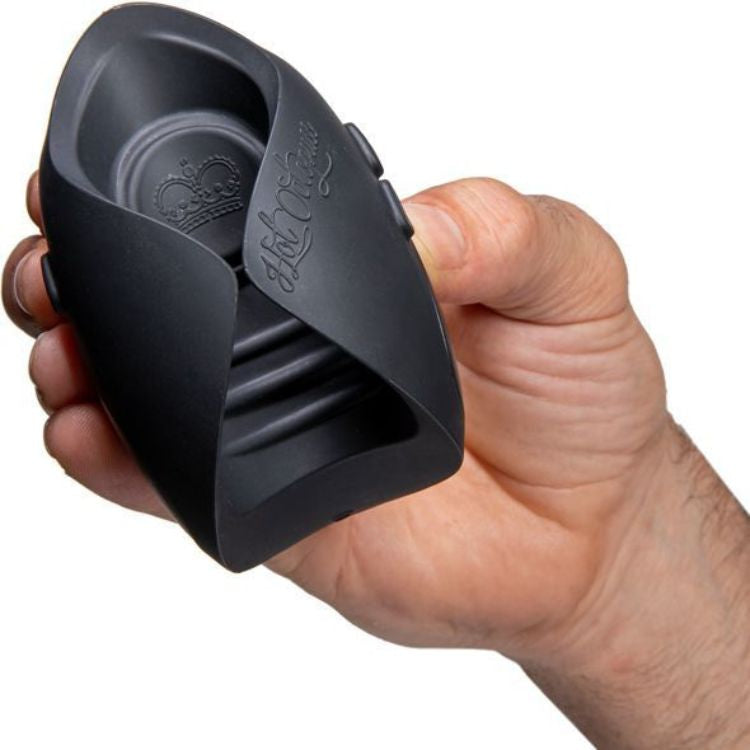 Hand holding a black silicone textured male stroker toy, discreet adult product