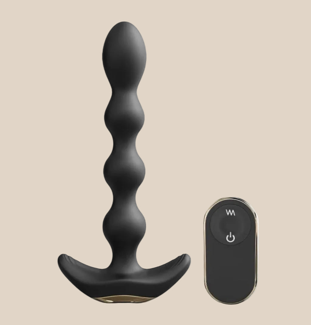 Black silicone vibrating anal beads with remote control on beige background