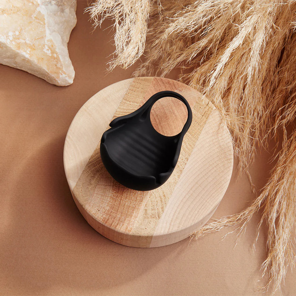 Black silicone vibrating ring on wooden display, intimate adult pleasure product