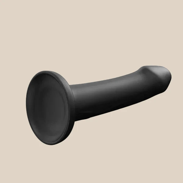 Black silicone strap-on dildo with flared base on neutral background