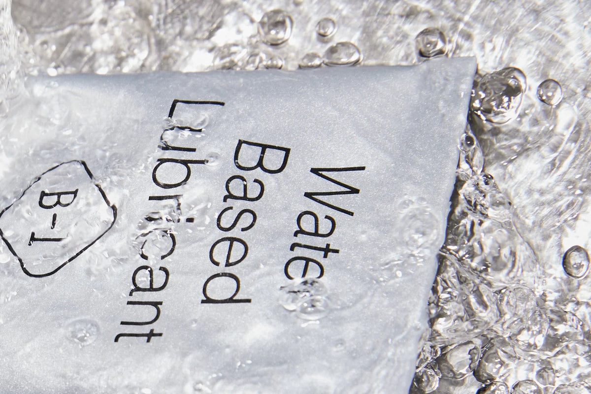 Water-based lubricant sachet partially submerged in clear water with bubbles