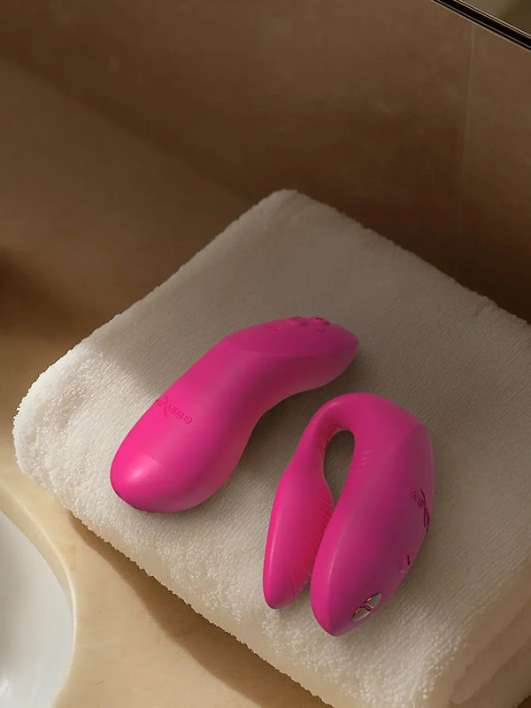 Lifestyle shot of the We-Vibe Chorus Pro in Electric Pink resting on a clean white towel in a modern bathroom setting for Noirette.