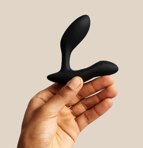 Alternative side view of the We-Vibe Vector Plus in Black held in hand to demonstrate the flexible neck and pivoting head.