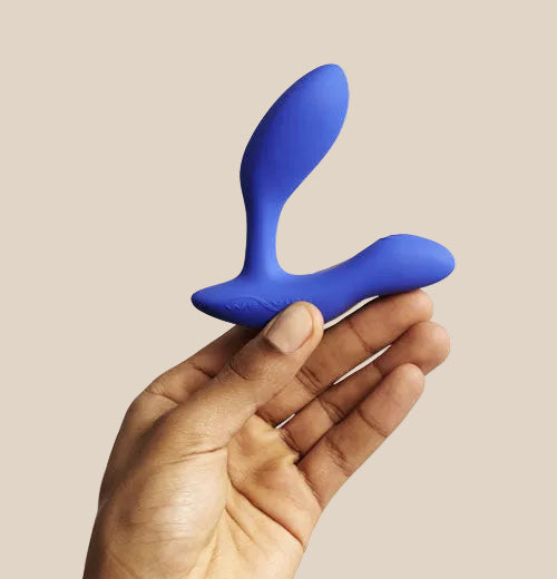 We-Vibe Vector Plus prostate massager in Royal Blue held in hand to show ergonomic size and scale