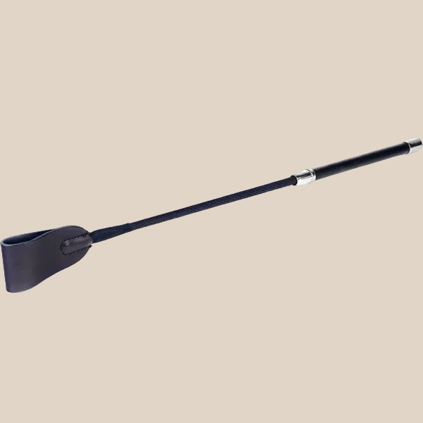 Black riding crop with leather tip and ergonomic handle on neutral background