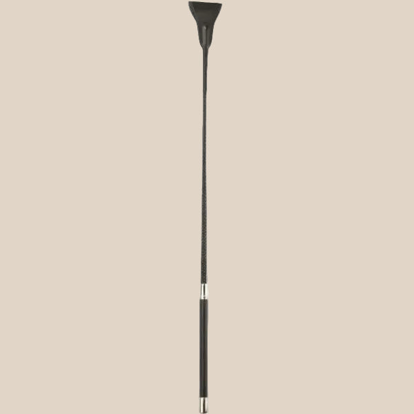 Black riding crop with faux leather tip and handle, sensual adult accessory on beige background