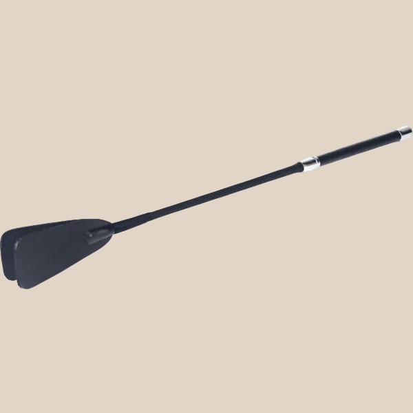 Black faux leather riding crop with long handle and silver accents on neutral background