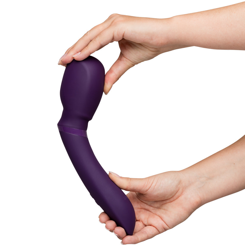 Hands holding a flexible, purple wand massager against a white background.