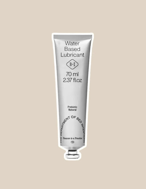 Silver tube of water-based lubricant, 70ml, labeled prebiotic and natural, on beige background