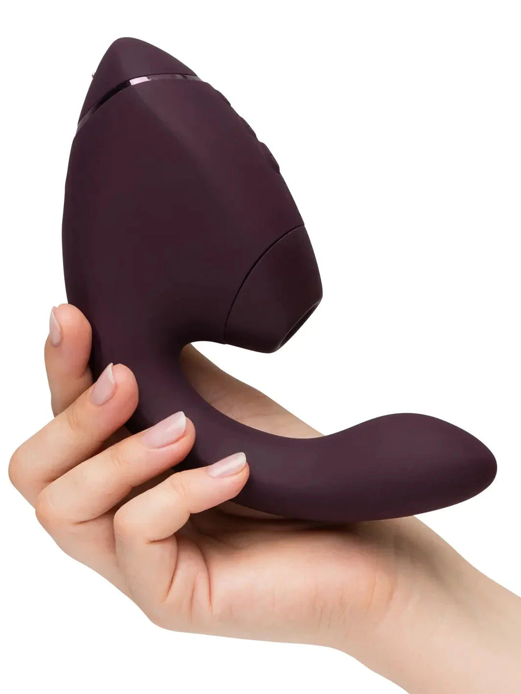 Holding the Dark Purple Womanizer Next Duo from Noirette to demonstrate product size and comfortable dual-stimulation design.