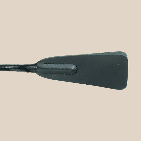 Black faux leather paddle with stitched details on a neutral background